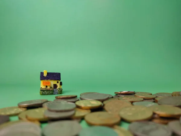 Мініатюрний Будинок Розкиданими Монетами Зеленому Тлі — стокове фото