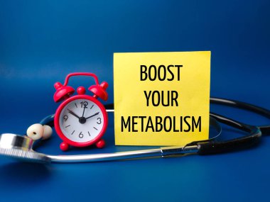 Çalar saat ve steteskopta BOOST sözcüğü mavi arka planda METABOLISM