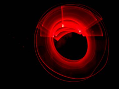 Kırmızı ışık, uzun pozlama fotoğrafçılık, dalgalanmalar ve siyah arkaplan ile yuvarlak desen.