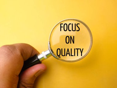 Sarı arka planda FOCUS sözcüğüyle el ele tutuşan büyüteç.