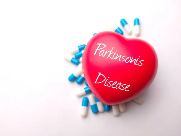 Red heart and pill with the word Parkinsonis Disease.