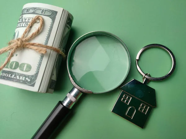 顶部视图钞票 放大镜和房子的钥匙链绿色背景 寻找新房子购买的概念 — 图库照片