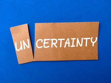 Üzerinde UNCERTAINTY yazan kahverengi kart.