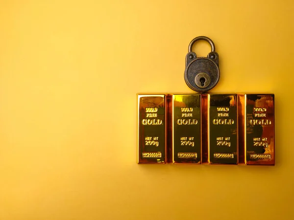 Vintage padlock with gold bar on a yellow background.