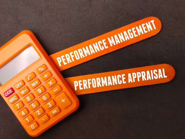 Colored wood and calculator with the word Performance Management,Performance Appraisal