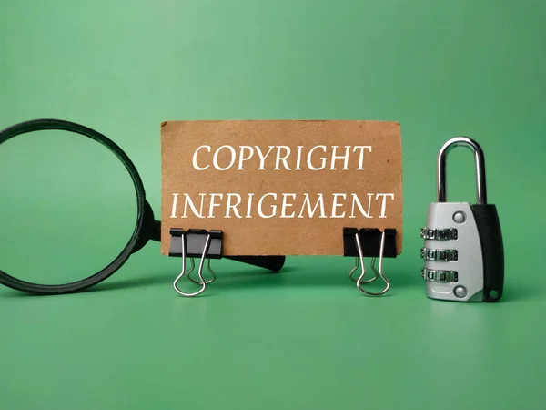Padlock and magnifying glass with the word Copyright Infringement on green background