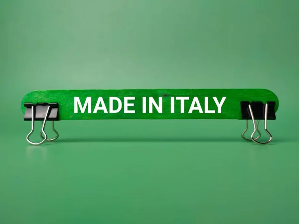 纸夹和木棍 绿色底色上写着意大利制造的字样 — 图库照片