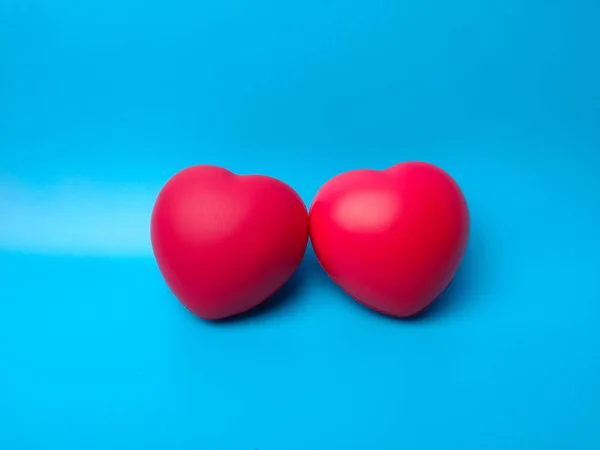 Close-up two red heart shape on blue background. Can use for heart check up or love concept