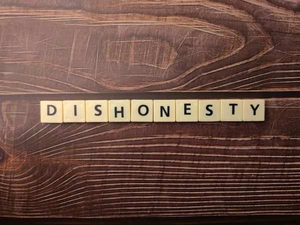 顶部视图玩具词 在木制背景上有 Dishonesty 这个词 — 图库照片