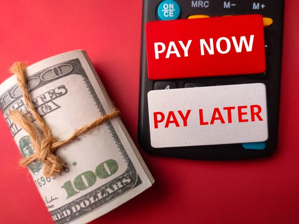 Банкноти Калькулятор Словом Pay Now Pay Later Червоному Тлі — стокове фото