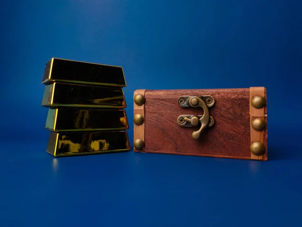 stock image Vintage wooden box with gold bar on blue background.