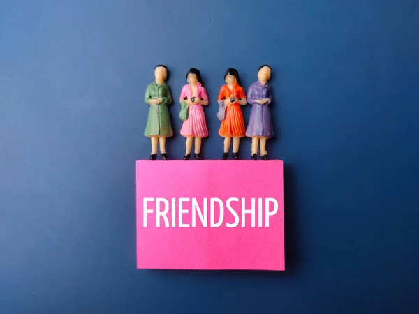 Miniaturmenschen Und Farbiger Zettel Mit Dem Wort Freundschaft Auf Blauem — Stockfoto