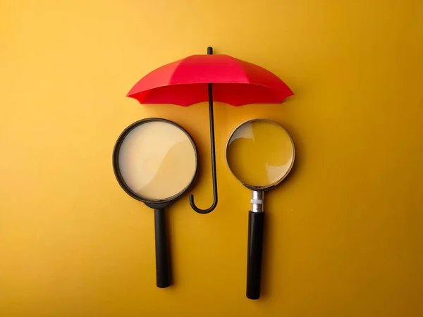 Piros Esernyővel Borított Nagyító Sárga Alapon — Stock Fotó
