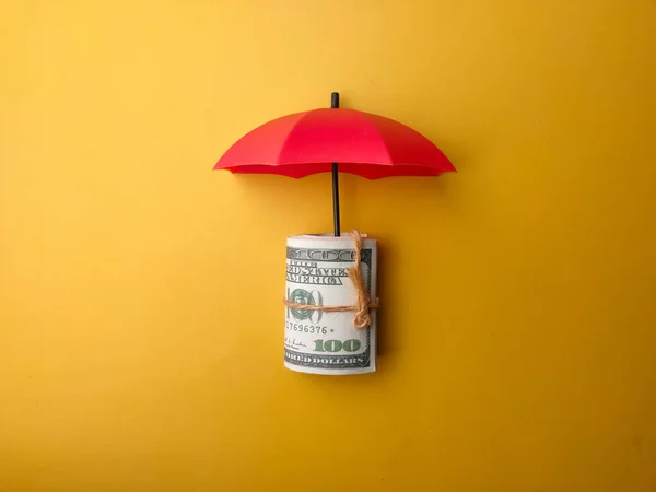 赤い傘は黄色の背景に紙幣を覆った — ストック写真