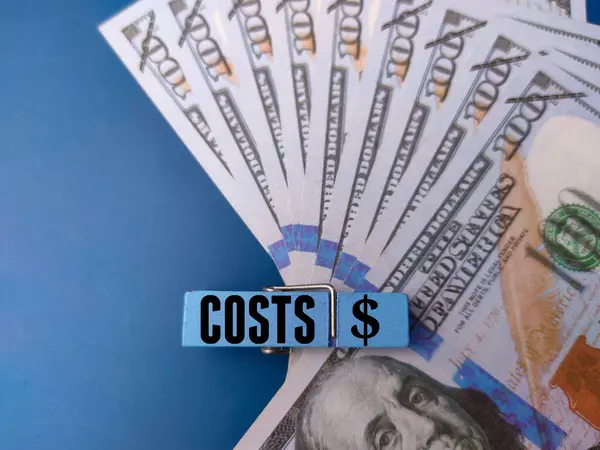 Τραπεζογραμμάτια Και Ξύλινα Κλιπ Λέξη Costs Μπλε Φόντο — Φωτογραφία Αρχείου
