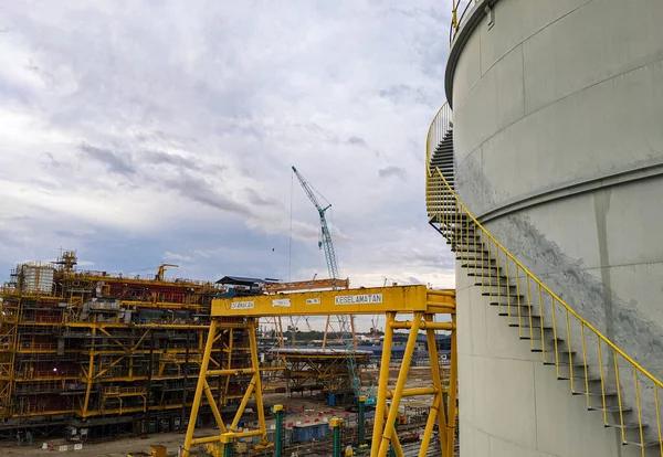 stock image Oil storage tanks in an industrial area with the background of the oil rig construction process.