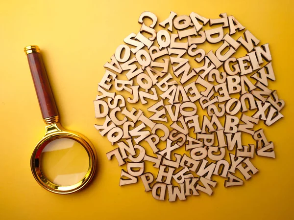 stock image Vintage magnifying glass and wooden word on a yellow background