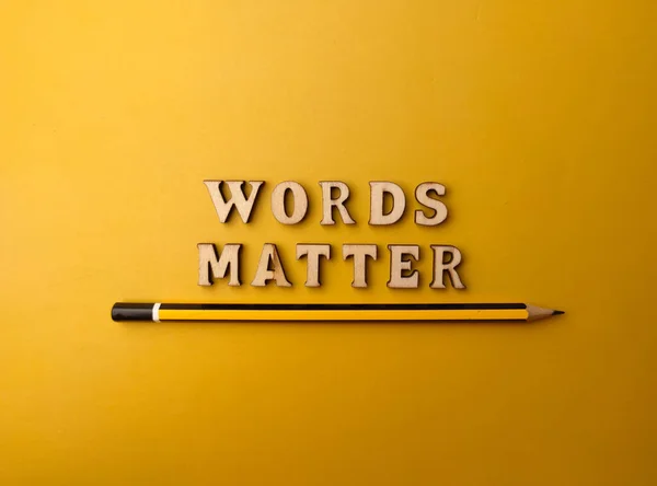 铅笔和木制字母玩具把单词 Words Matter 排列成黄色背景 — 图库照片