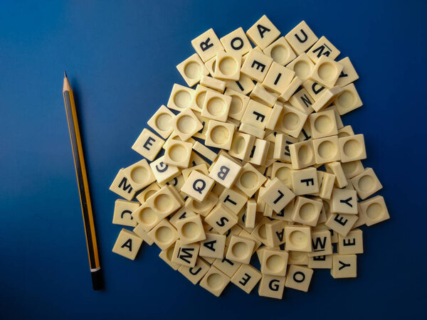 Top view toy letters and pencil on blue background