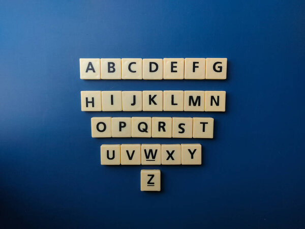 Top view set of 26 toy letters,whole alphabet on blue background