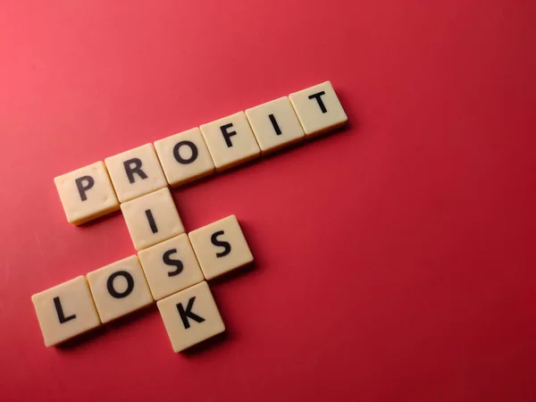 红色背景下印有Profit Risk Loss字样的Closeup玩具字母 — 图库照片