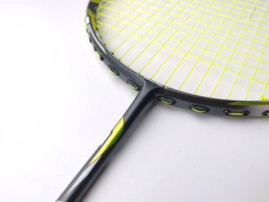 Manjung, Perak-July 7 2023: Beyaz arka planda izole edilmiş yeşil ipli beyaz ve siyah badminton raketi