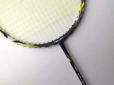 Manjung, Perak-July 7 2023: Beyaz arka planda izole edilmiş yeşil ipli beyaz ve siyah badminton raketi