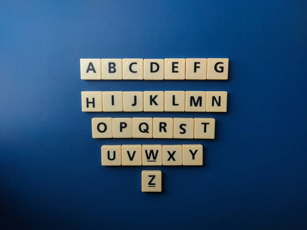 Top view set of 26 toy letters,whole alphabet on blue background
