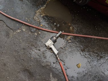 Islak zemine yerleştirilmiş bir arabanın lastiğini sökmek için bir rüzgar silahı.