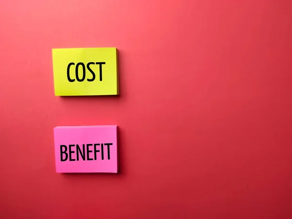 Stock image Colored sticky note with the word COST CREDIT on a red background