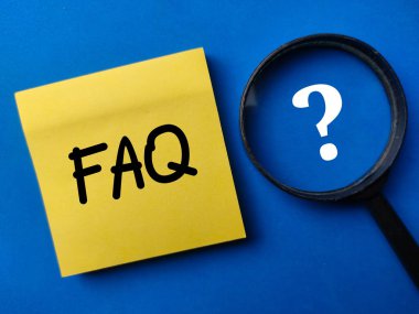 Magnifying glass and sticker note with the word FAQ on a blue background