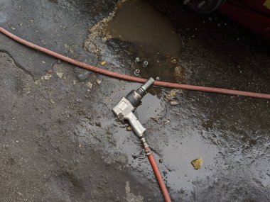 Islak zemine yerleştirilmiş bir arabanın lastiğini sökmek için bir rüzgar silahı.