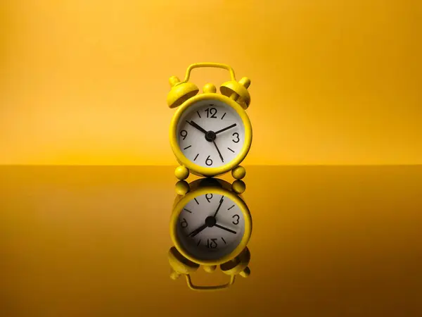 Reloj Despertador Amarillo Sobre Fondo Amarillo Con Reflexión Sobre Tablero — Foto de Stock