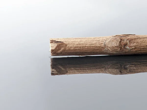 Крупный План Деревянной Палки Отражением Черной Акриловой Доске — стоковое фото