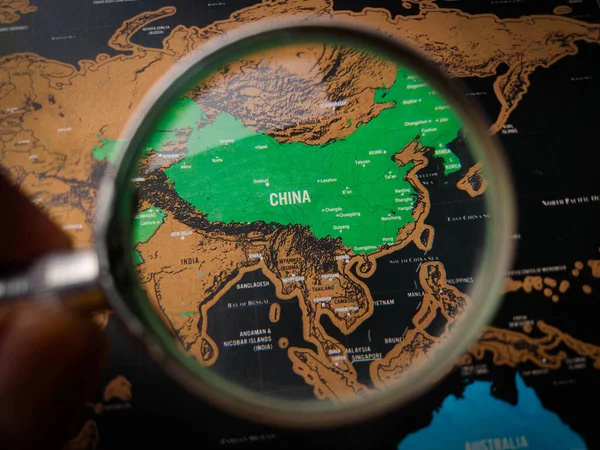 Top view hand holding magnifying glass and focus to CHINA map