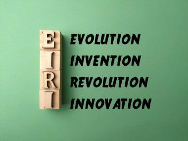 Tahta blok ve kelime ile kelime EVOLUTION REVİYON Yeşil arka planda İSTİYON.