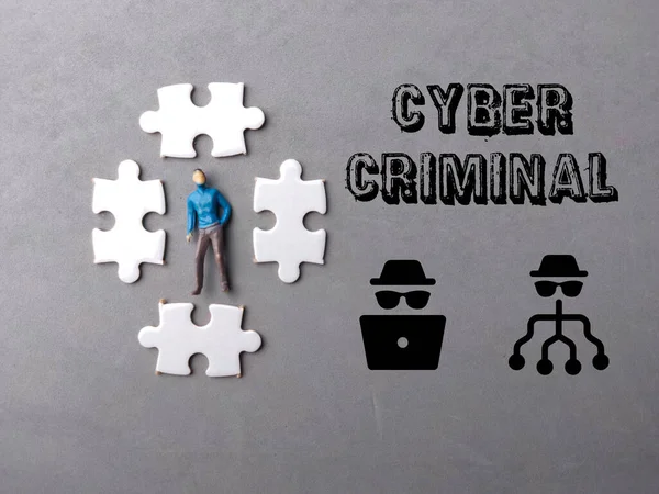 Top view miniature people and puzzle with text CYBER CRIMINAL on gray background.Cyber security concept.