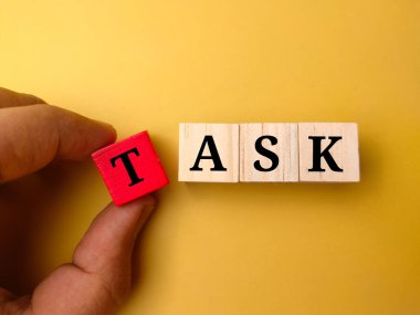 TASK sözcüğüyle el ele tutuşan ahşap küp
