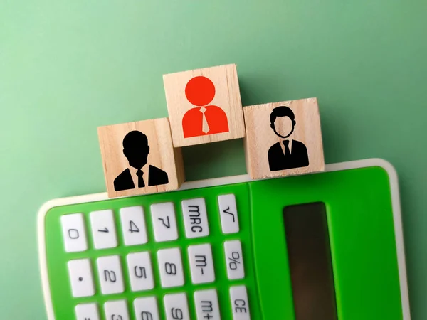 stock image Wooden block and calculator with an old employee icon and a new employee is included. business concept