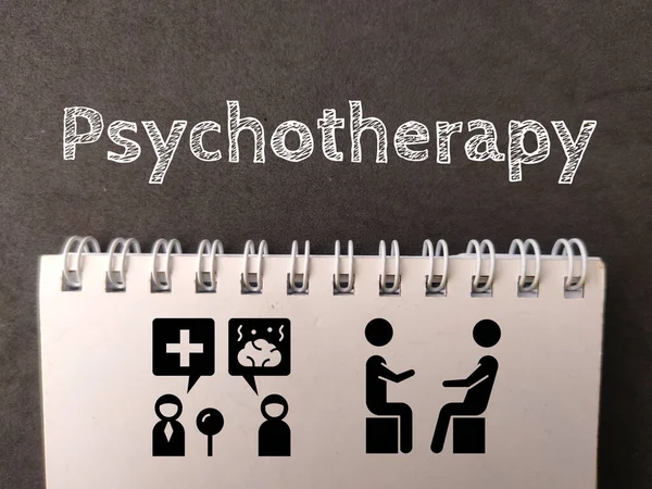 黑色背景下的带文本心理治疗的笔记本和图标 图库图片