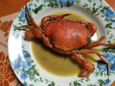 Beyaz tabakta yengeç çorbası. Bu çorba ateşin olduğunda yemek için uygundur..
