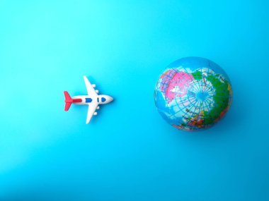 Mavi arka planda dünya küresi olan en iyi görüntü uçağı. Seyahat kavramı.