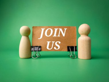 Yazılı iki tahta bebek yeşil arka planda bize katılıyor.