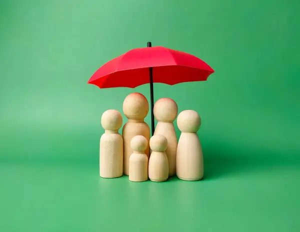 A wooden peg doll family cover by red umbrella on a green background