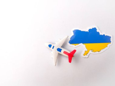 Üst manzara Ukrayna bayrağı ve beyaz arka planda oyuncak uçakları.