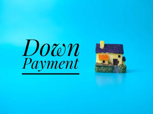 Miniature house with text Down Payment on blue background.