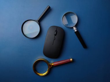 Üst görünüm büyüteç ve mavi arkaplanda kablosuz fare