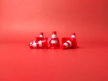 Mini Plastik Koniler Spor Eğitimi Kırmızı arka planda dağınık.