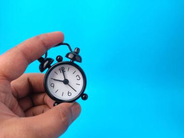 Kopya alanı olan mavi bir arkaplanda siyah alarm saati..