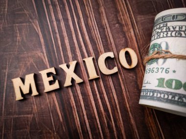Üst görünüm banknotları ve ahşap arkaplanda MEXICO yazılı ahşap sözcük.